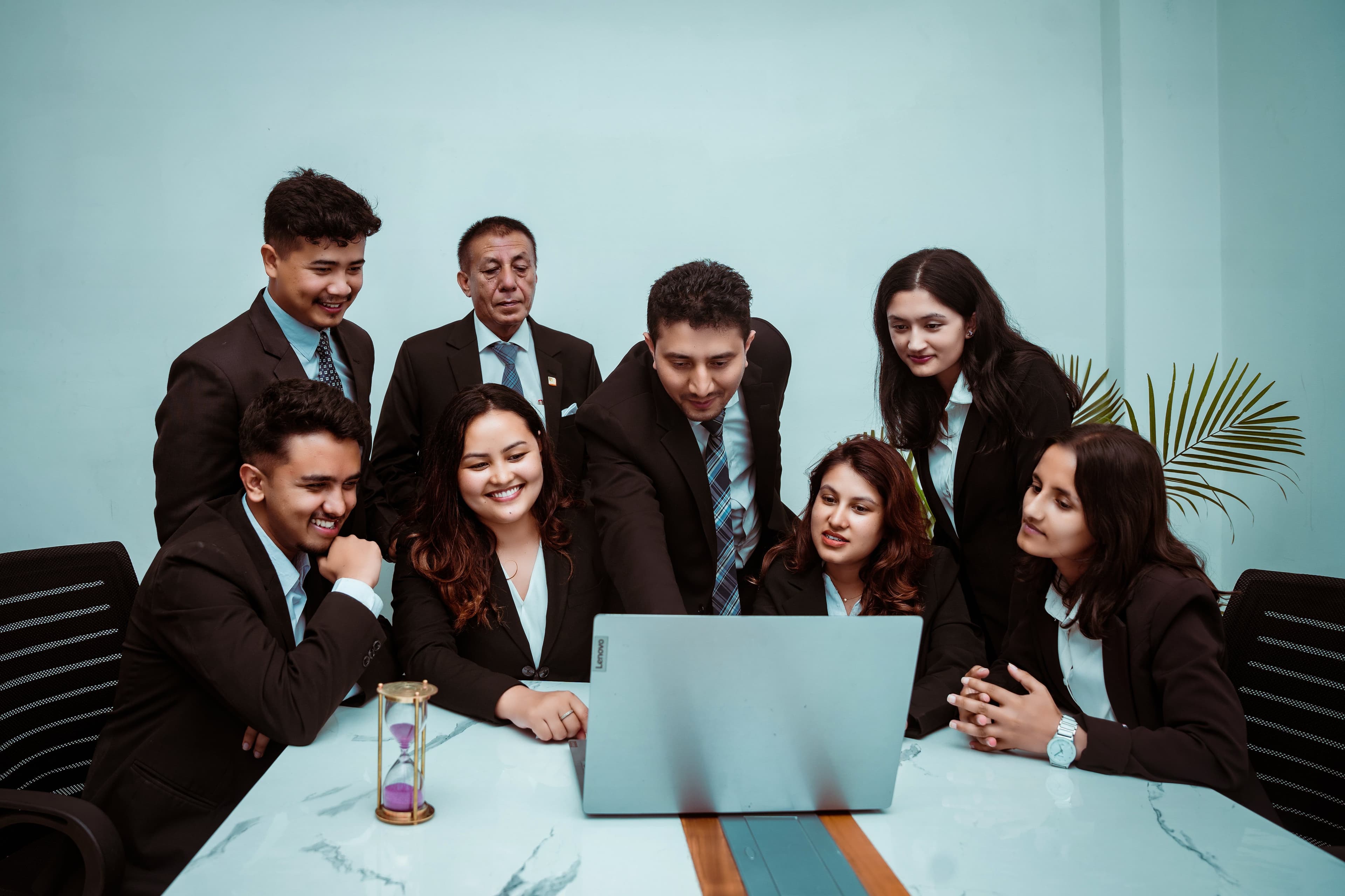 A diverse team of professionals collaborating around a laptop