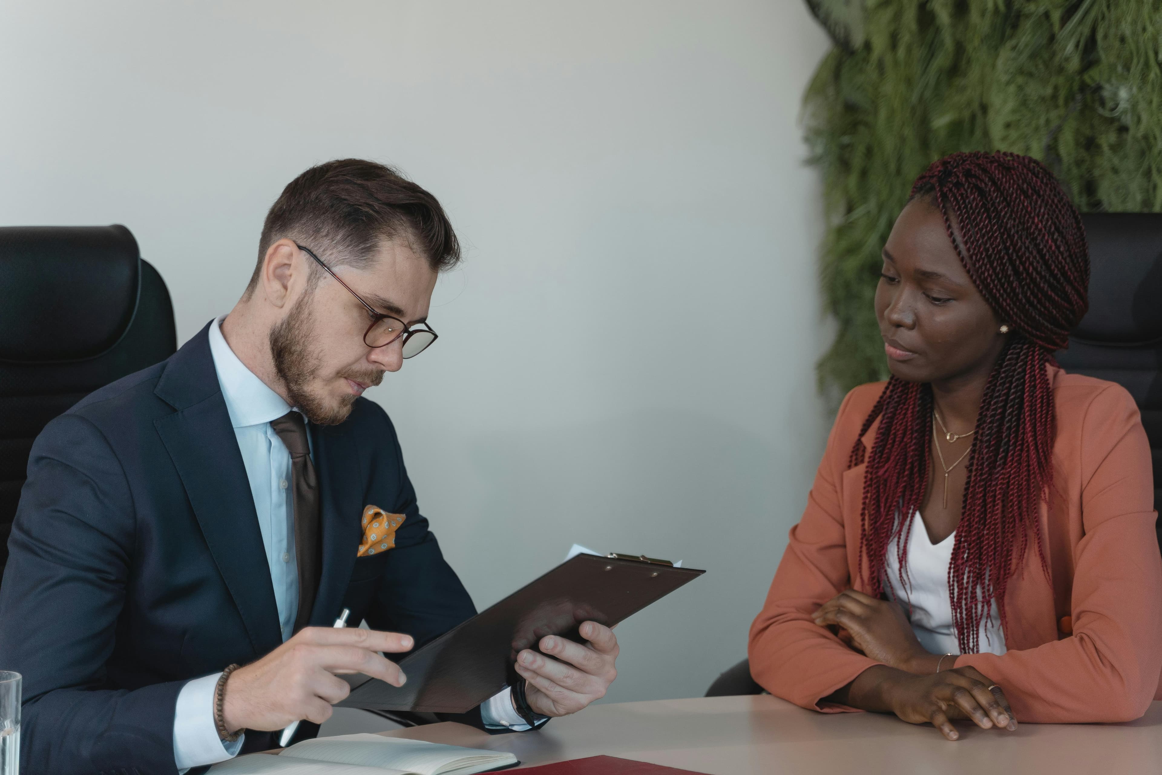 A man and woman engaging in a job interview in a modern office setting