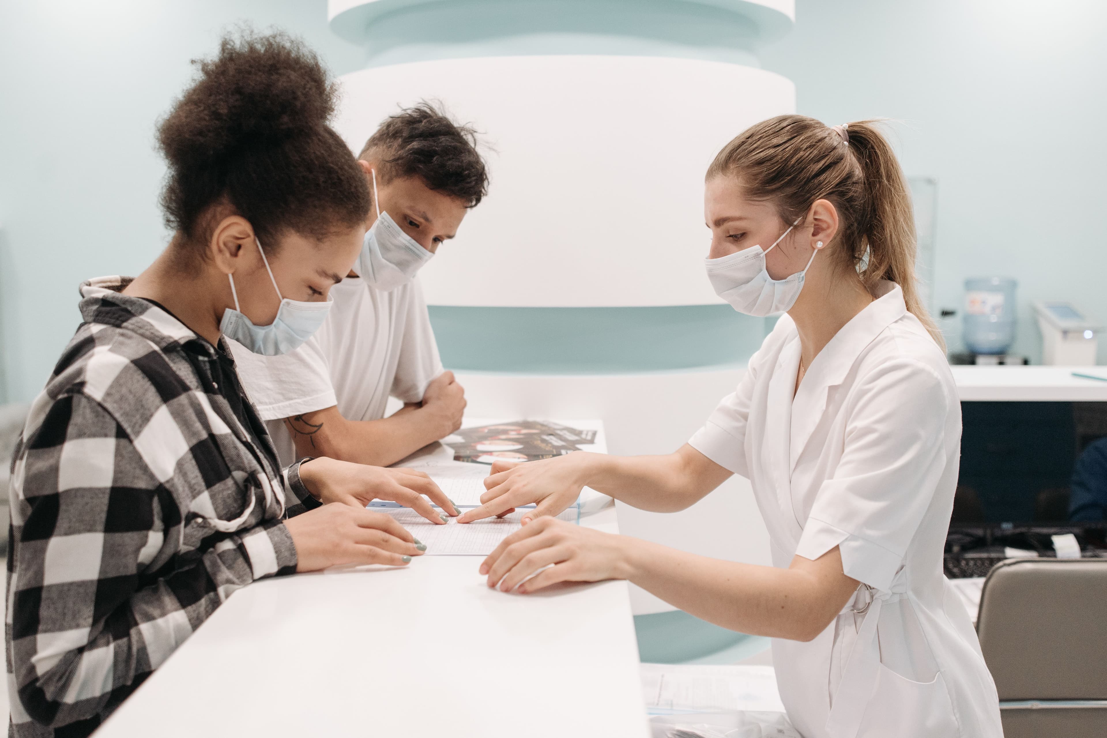 A healthcare professional assists patients at a clinic desk