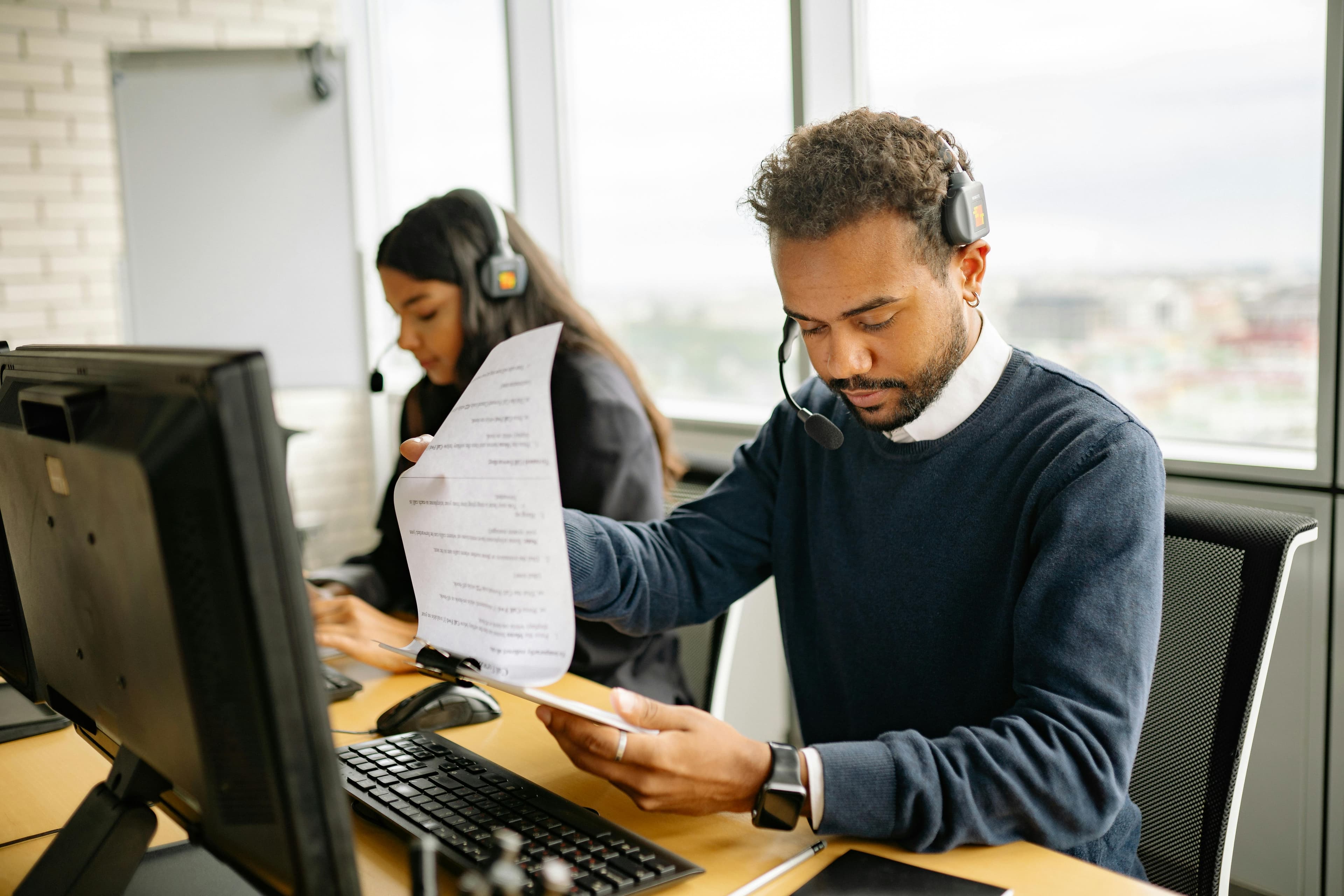 Man reading a printed document in an office setting