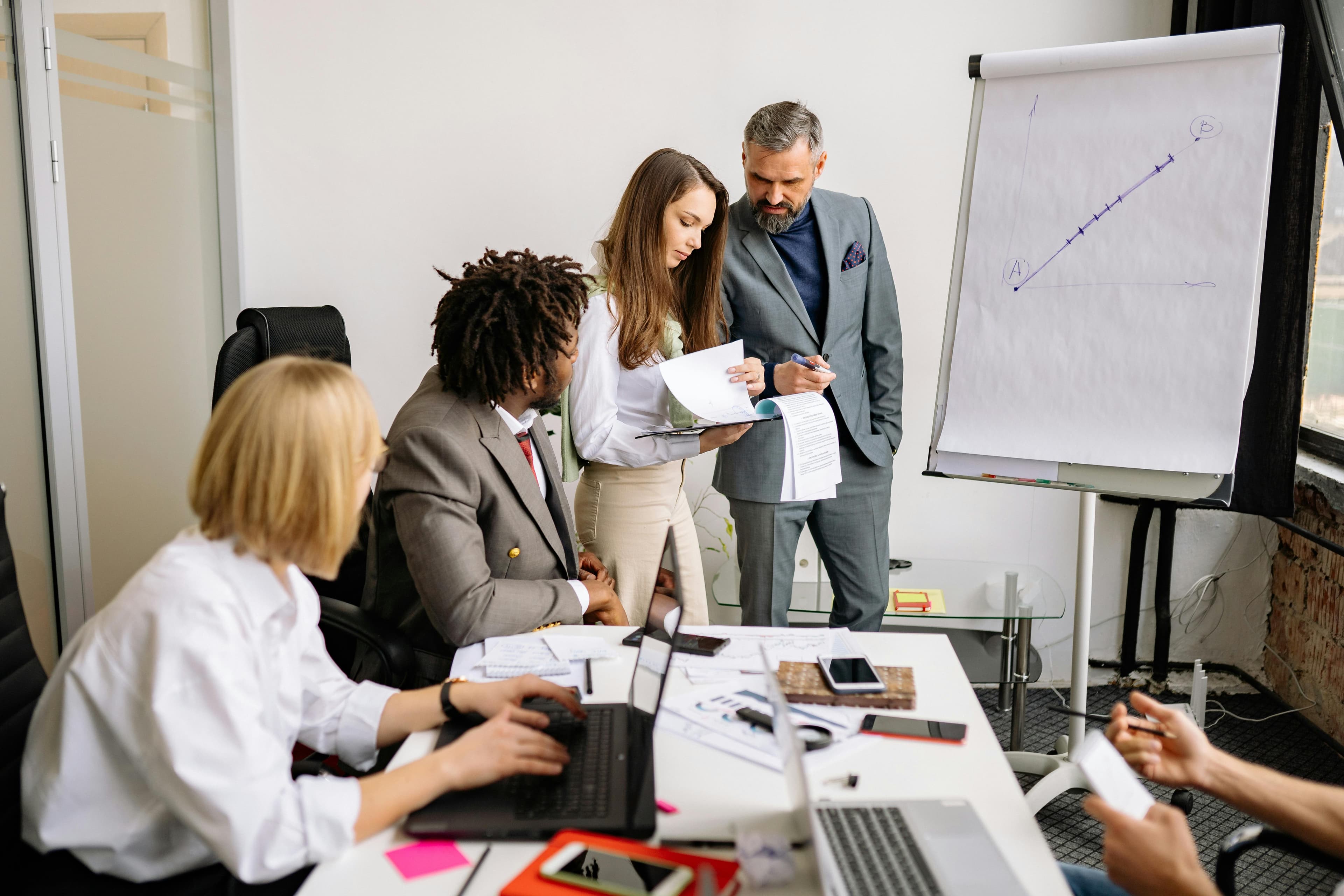 Men and women discussing near a whiteboard