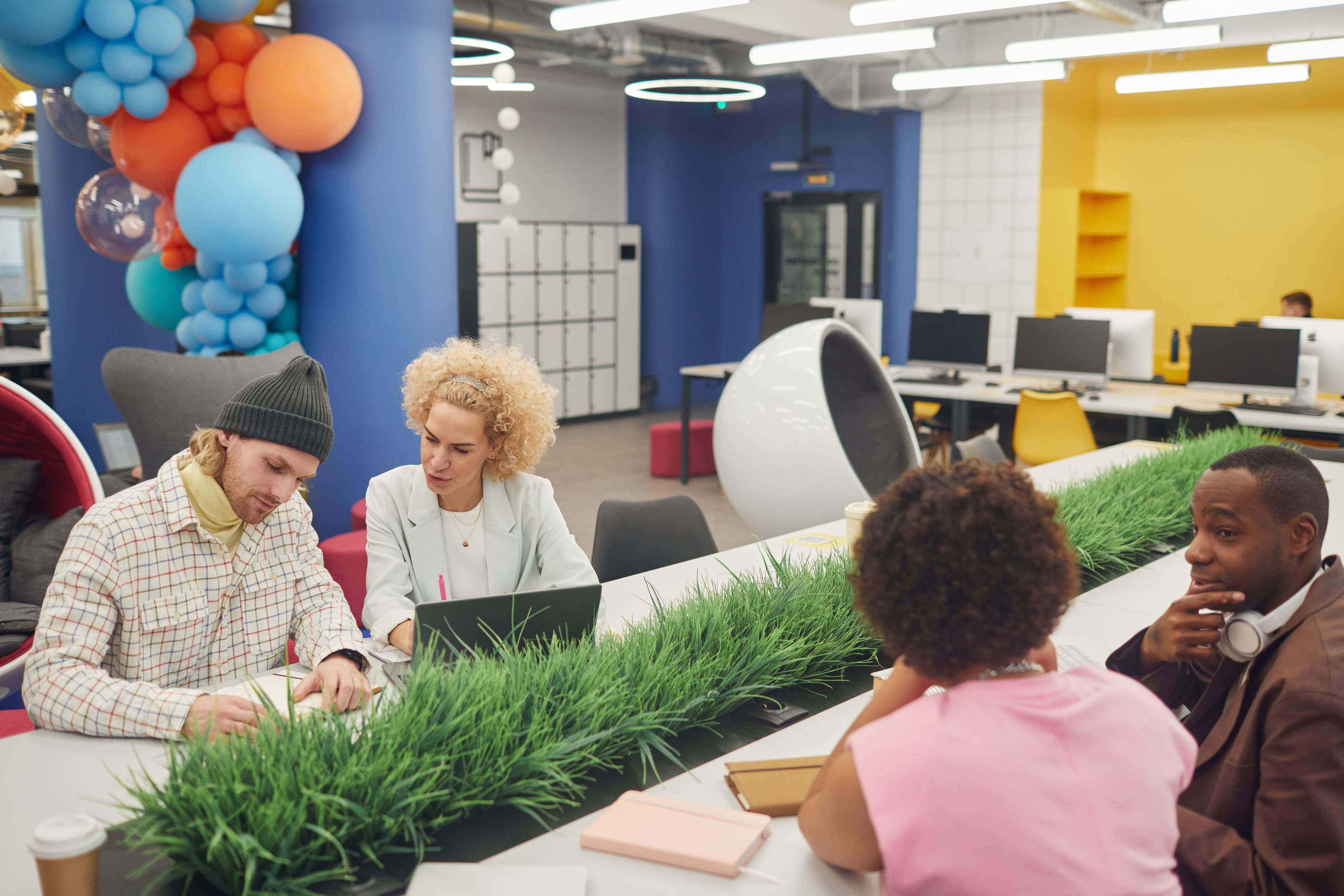 Diverse team collaborating creatively in a modern, colorful office workspace