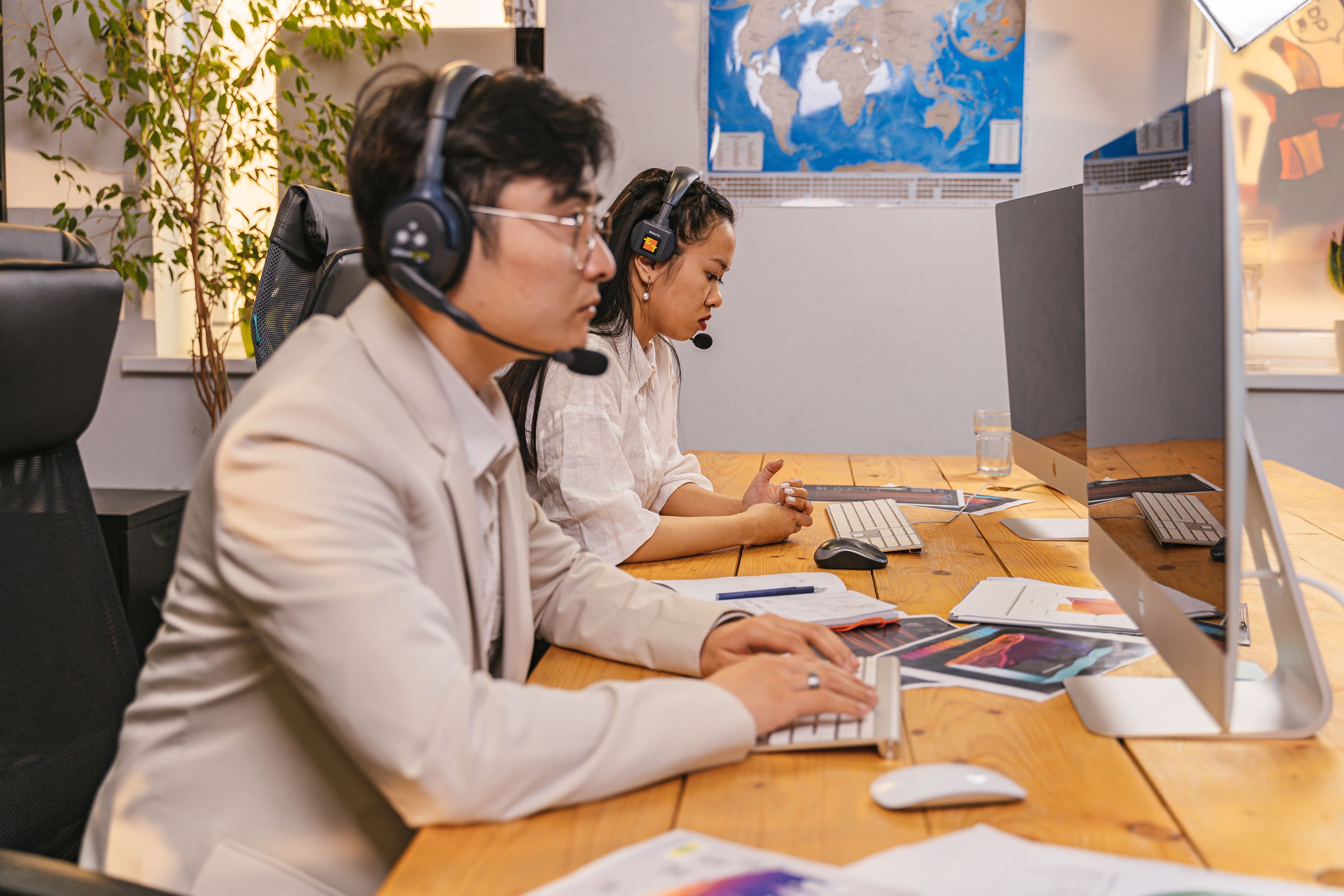 Call center agents working at computers with headsets