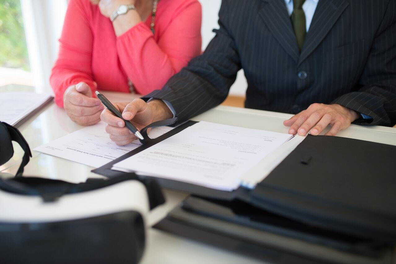 Man Holding Pen Explaining Documents